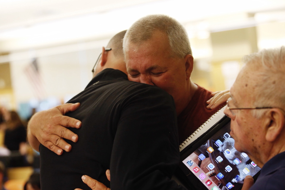Dennis Munroe of Biddeford hugs Matt Lauzon after Lauzon spoke to the council. Commenting after the meeting, Mayor Alan Casavant said he felt the gathering was productive and offered councilors the chance to hear “heartfelt” testimony.