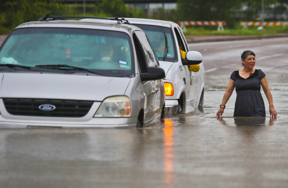A municipal vehicle pushes a stranded van that attempted to make it through the high waters along Mexico Boulevard in Brownsville, Texas, on Thursday.