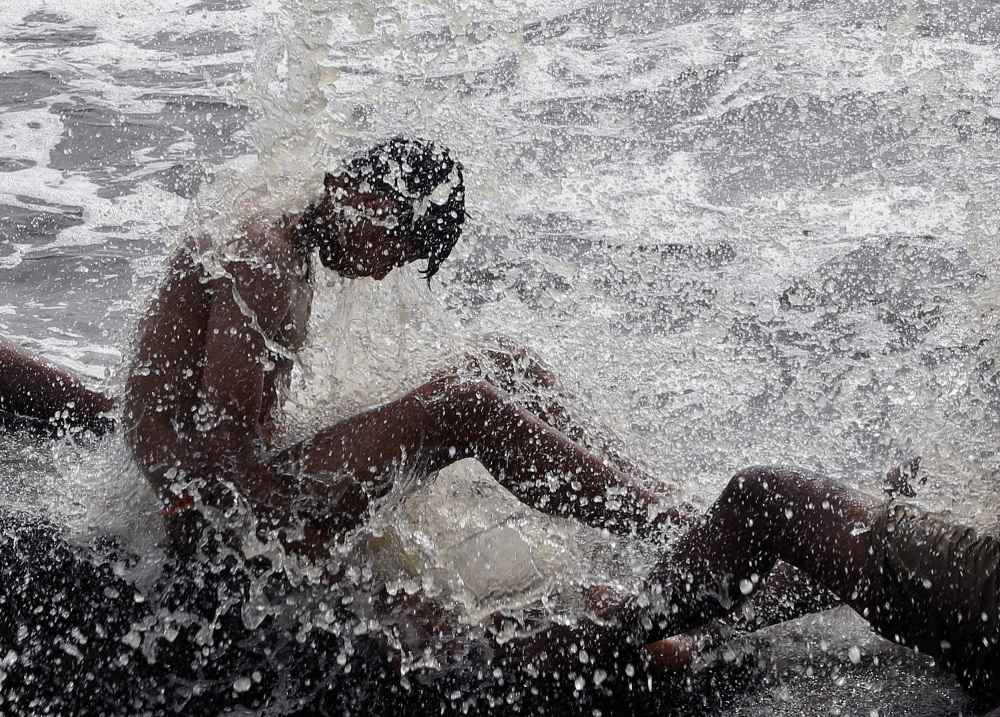 An man enjoys high tide waves at the Arabian Sea coast in Mumbai, India, on Friday. Two southern India states are facing their highest sustained temperatures in 12 years.