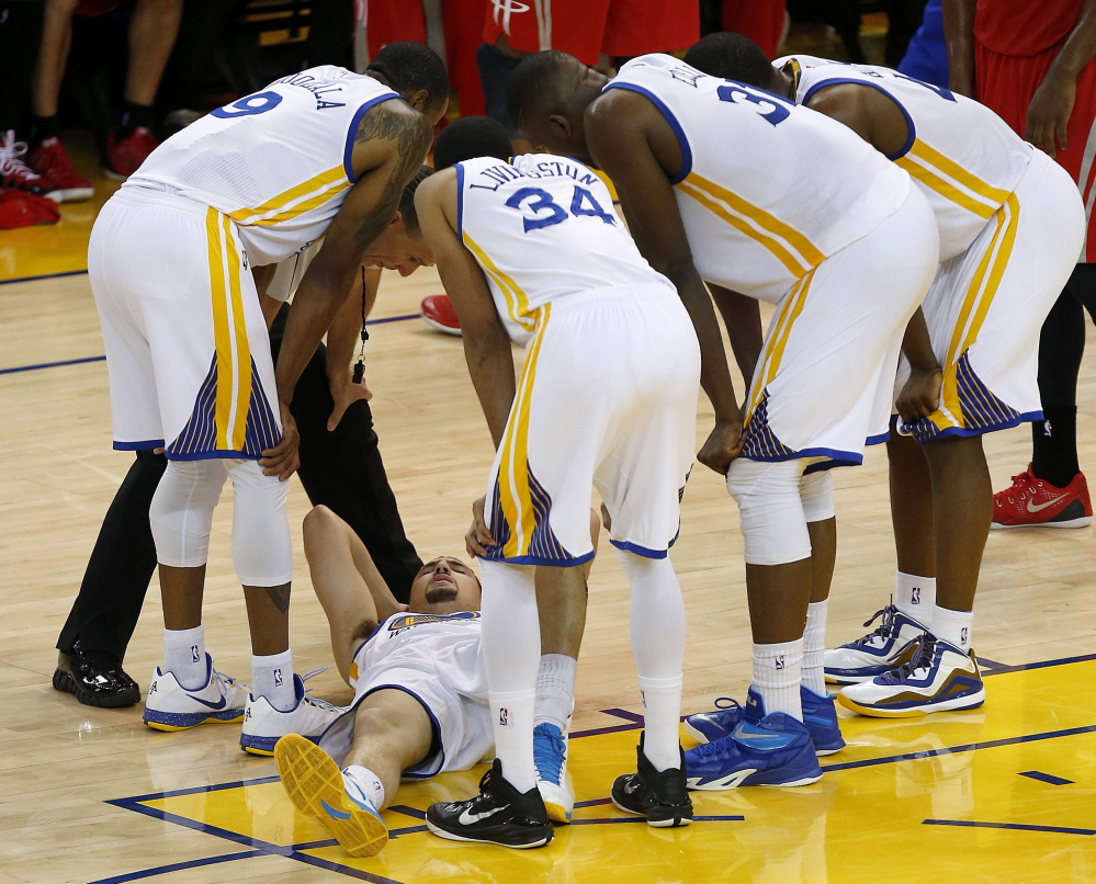 Warriors guard Klay Thompson is checked on by teammates after taking a knee to his head Wednesday. It was later determined that Thompson had sustained a concussion.