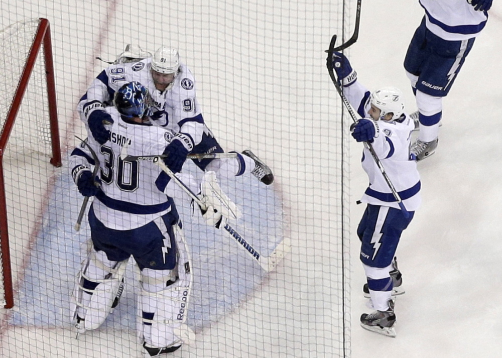 The Tampa Bay Lightning rush to embrace goalie Ben Bishop after their 2-0 win over the New York Rangers in Game 7 of the Eastern Conference finals at Madison Square Garden.