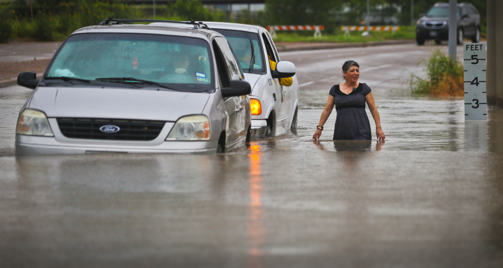 A city of Brownsville vehicle pushes a stranded van that attempted to make it through the high waters as a woman walks alongside Thursday.
The Associated Press 
