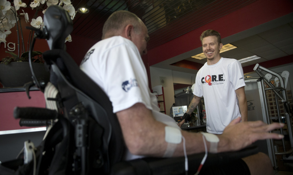 Aaron Baker, right, talks to a client at the Center for Restorative Exercise, a gym he co-founded for people recovering from spinal-cord and other debilitating injuries.