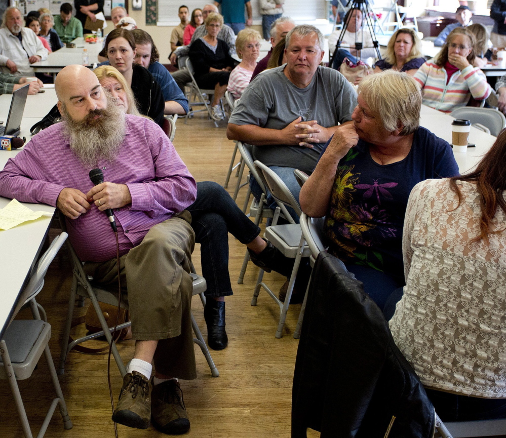 People listen as Rick Alexander, at left, speaks at a forum in Biddeford this month for victims of alleged abuse by former members of the Biddeford Police Department.