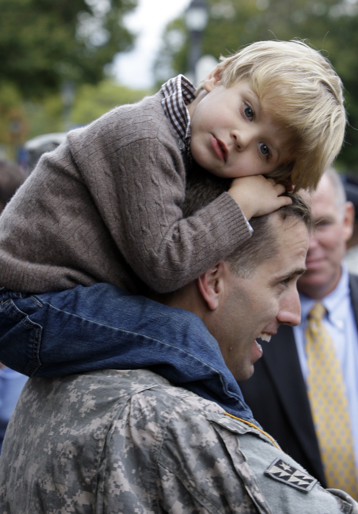 Capt. Beau Biden carries his son Hunter, 3, on his shoulders after an official welcome home ceremony for members of the Delaware Army National Guard 261st Signal Brigade in Dover, Del., in 2009.