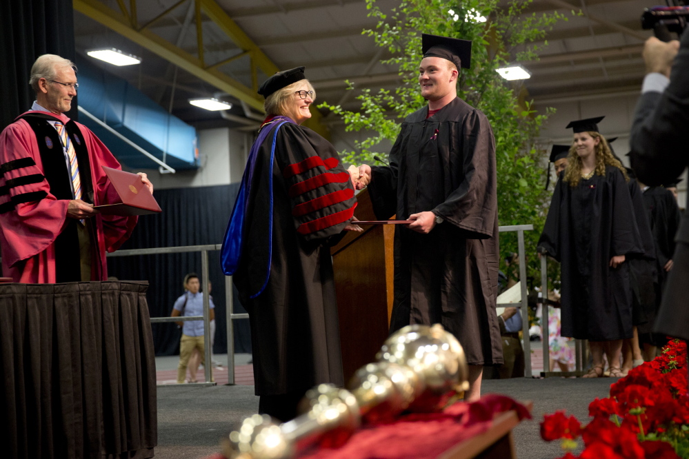 Bates President Clayton Spencer hands out a diploma.