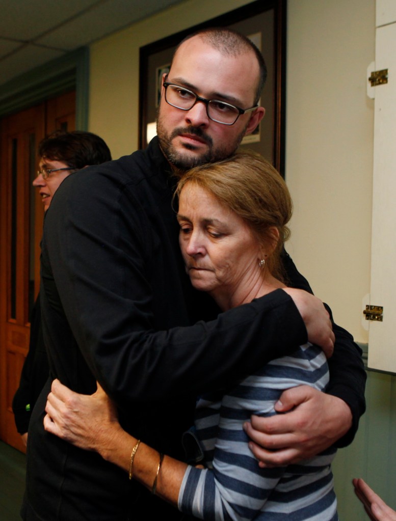 Matthew Lauzon comforts his mother, Debbie Lauzon, after her confrontation during Tuesday night's Biddeford City Council meeting with a registered sex offender whom he has accused of sexually abusing him.