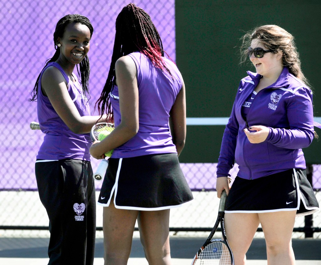 Domingas Nzuzi, left, of Angola, Gemima Masangu, center, of the Democratic Republic of Congo, and Cassi Bigelman of the Cayman Islands are part of Deering’s diverse tennis team. Katie Ewald photo
