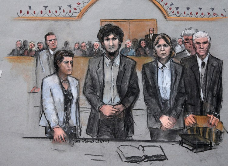 In this courtroom sketch, Boston Marathon bomber Dzhokhar Tsarnaev, center,  stands with his defense attorneys as a death by lethal injection sentence is read at the Moakley Federal Court House in Boston on Friday.