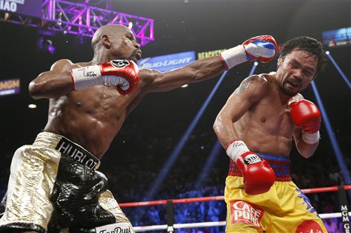 Floyd Mayweather Jr., left, hits Manny Pacquiao during their welterweight title fight Saturday in Las Vegas. The Associated Press