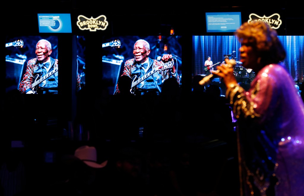 Pictures of B.B. King are displayed on a screens as Shirley King, the eldest daughter of B.B. King, performs Friday, May 22, 2015, in Las Vegas. Shirley King hosted and performed at a free musical event at the Brooklyn Bowl. (AP Photo/John Locher)