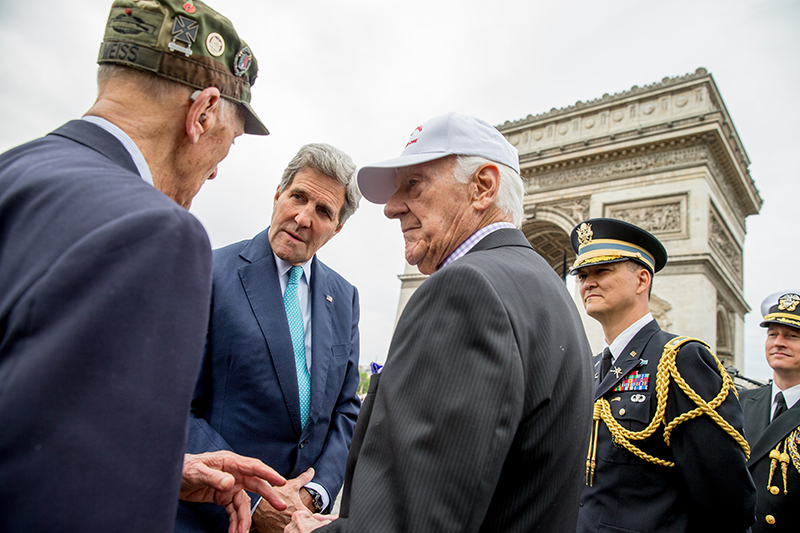 U.S. Secretary of State John Kerry greets American World War II veterans Arthur Staymates, 89, left, and Stephen Weiss, 90, center, following a wreath laying ceremony at the Tomb of the Unknown Soldier in Paris during France's 70th anniversary of V-E Day.
