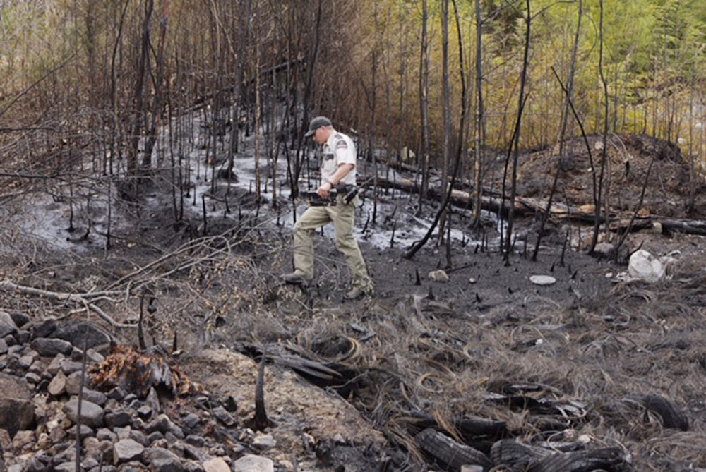 Matthew Bennett of the Maine Forest Service examines the aftermath of a fire at 183 S. Bridgton Road in Bridgton on Tuesday.
Gregory Rec / Staff Photographer
