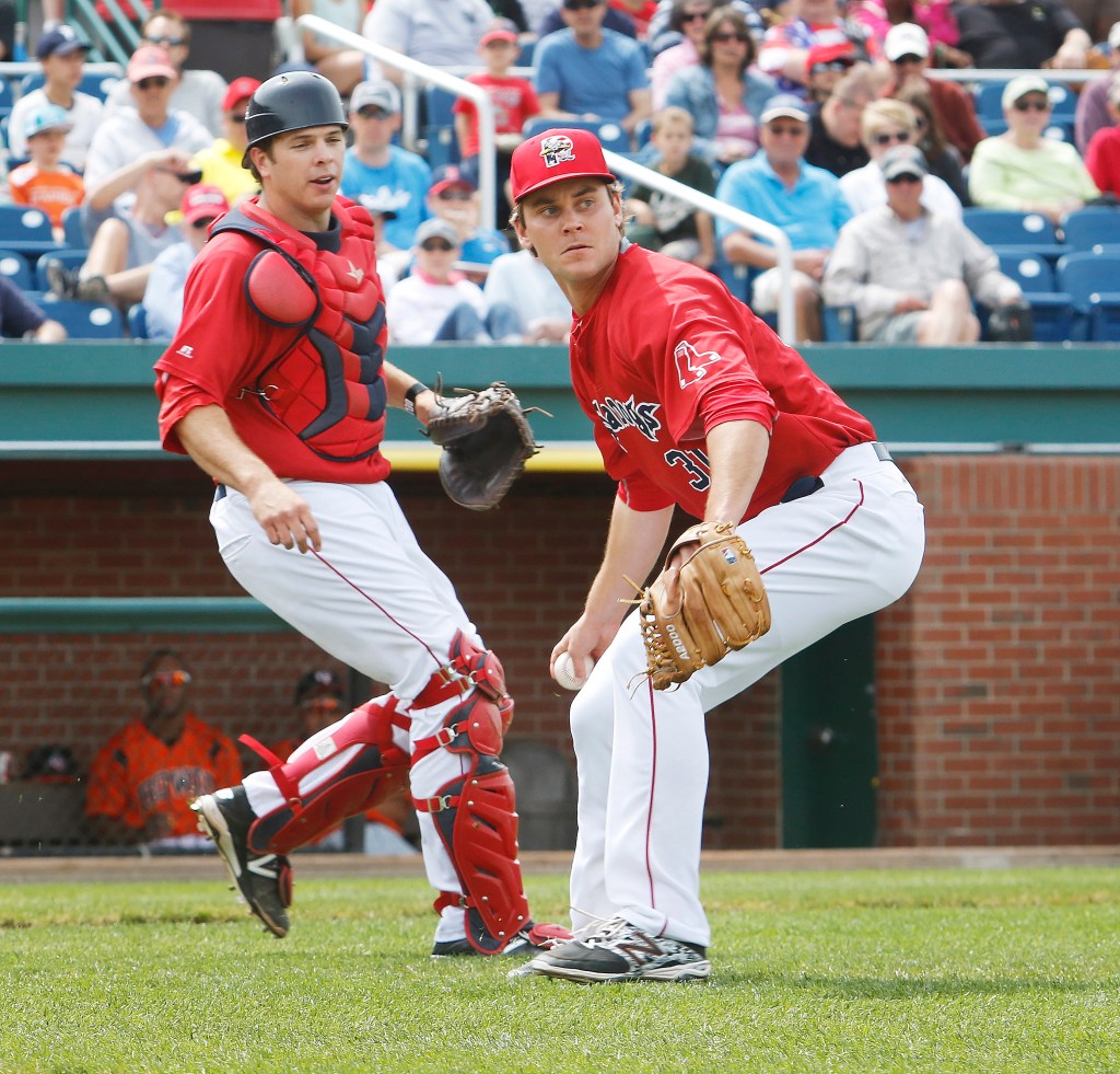 Sea Dogs reliever Madison Younginer gets ready to throw to first base for an out after fielding a ground ball while catcher Tim Roberson looks on Sunday at Hadlock Field. Jill Brady/Staff Photographer