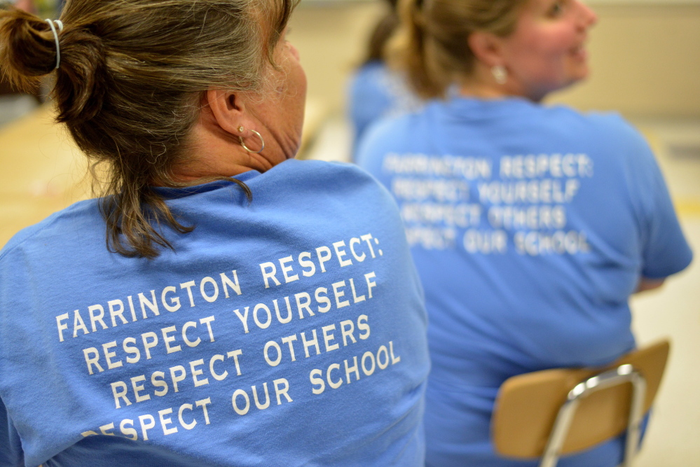 Teachers wear T-shirts in support of their school Tuesday during a news conference held at Farrington Elementary School in Augusta to address allegations that Farrington teachers left posters on the wall that offered assistance to students during standardized testing.
