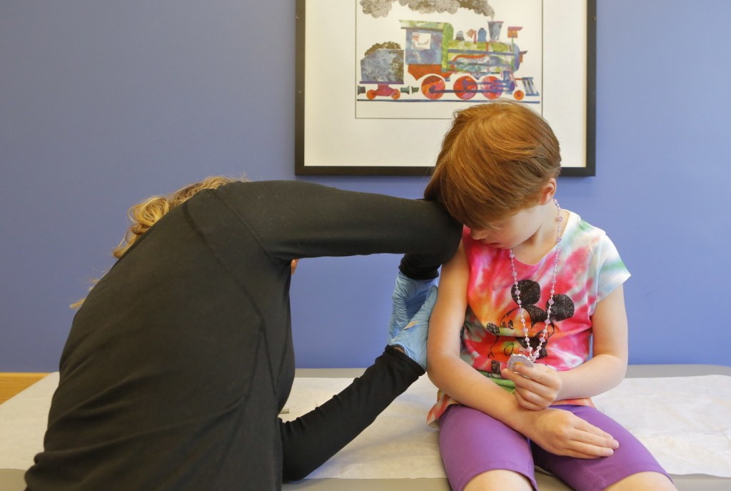 Kiara Boisvert, 5, gets a varicella booster vaccination Thursday from Amy Moran, a clinical assistant at Intermed in South Portland. Photo by Gregory Rec/Staff Photographer