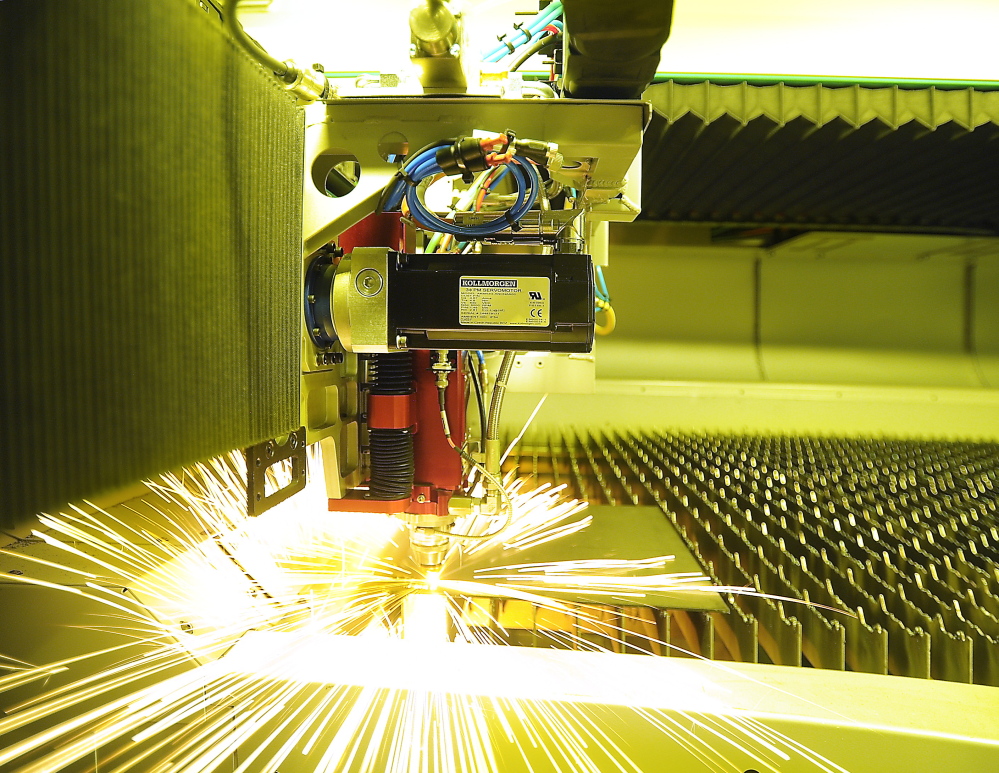 A computer-controlled laser machine cuts a metal plate during the fine-tuning of equipment being installed at Modula storage products in Lewiston. Once the installation is done, the company will need more workers.