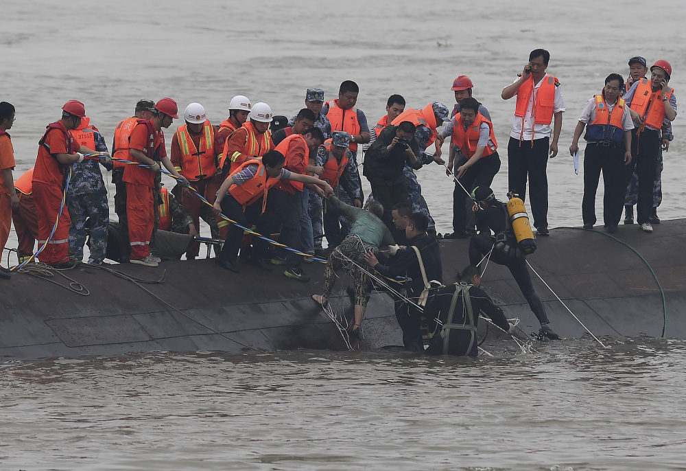 In this photo released by China’s Xinhua News Agency, rescuers save a survivor, center, from the overturned passenger ship in the Jianli section of the Yangtze River in central China’s Hubei Province on Tuesday.