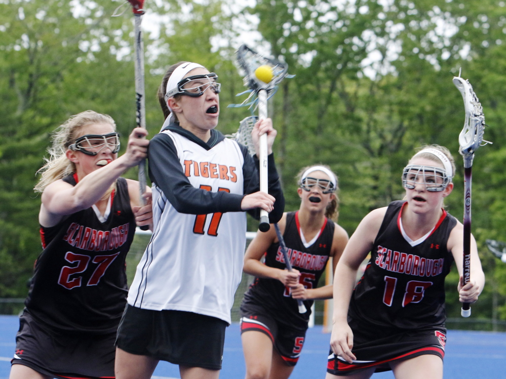 Cassidy Petit of Biddeford is surrounded by Kaitlin Prince, left, Ellie Smith, center, and Alex McCown of Scarborough during the first half of Scarborough’s 13-6 victory in a girls’ lacrosse game Tuesday at Biddeford.