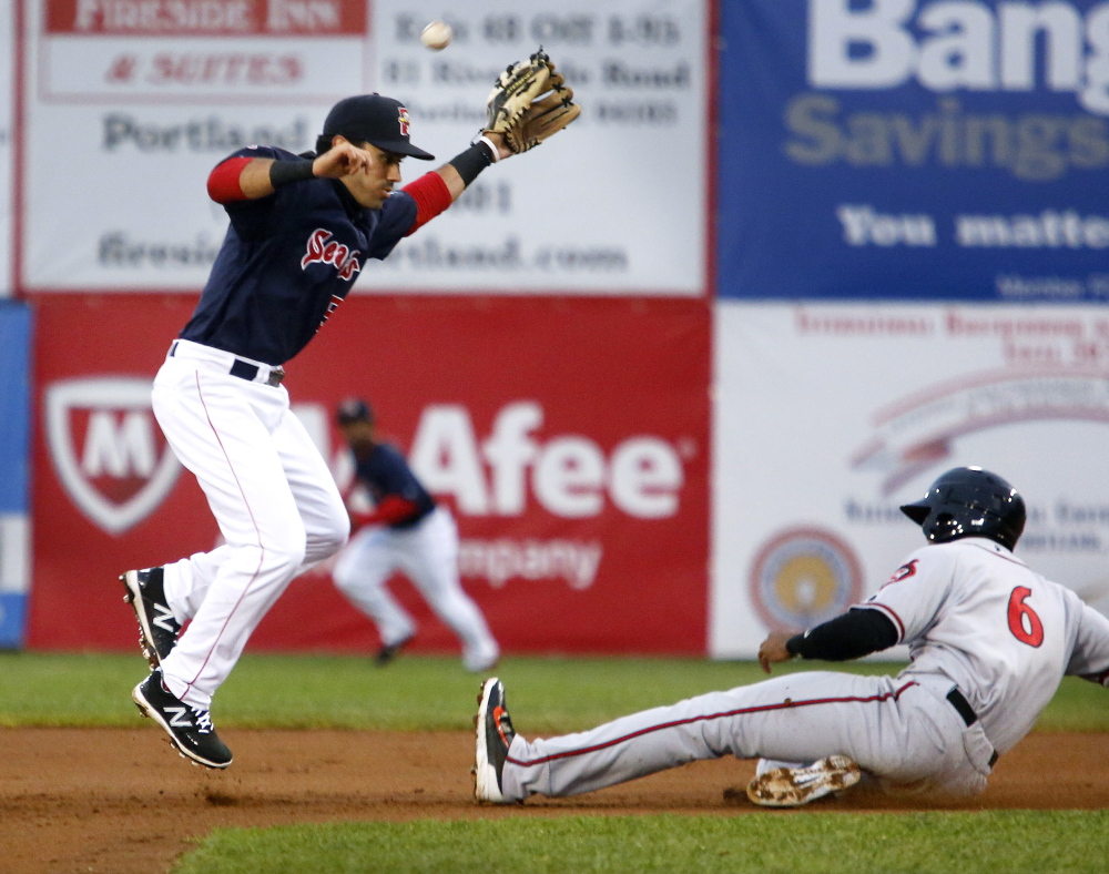 Carlos Asuaje of the Sea Dogs avoids Richmond’s Daniel Carbonell as a throw sails wide during the fourth inning Tuesday night at Hadlock Field. Richmond held on for the 4-3 win.
