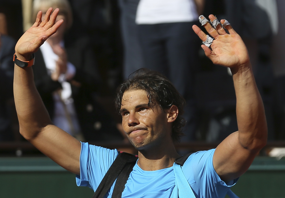 Spain’s Rafael Nadal waves goodbye to spectators as he leaves center court while Serbia’s Novak Djokovic celebrates winning the quarterfinal match of the French Open tennis tournament in three sets, 7-5, 6-3, 6-1, at the Roland Garros stadium, in Paris, France, on Wednesday.