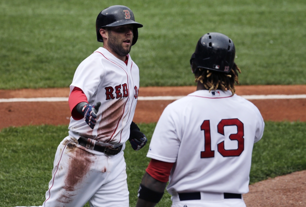 Boston’s Dustin Pedroia, is congratulated by Hanley Ramirez after scoring on a double by designated hitter David Ortiz in the first inning Wednesday against the Minnesota Twins.