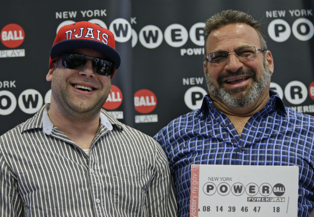Anthony Perosi, right, holds a copy of the winning Powerball ticket with his son, Anthony Perosi III, in New York on Thursday.
