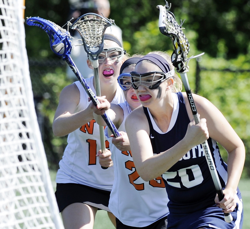 Shannon Fallon of Yarmouth takes the ball to the net for a goal while eluding the North Yarmouth Academy defense during their schoolgirl lacrosse regular-season finale Thursday. Yarmouth earned a 15-3 victory.