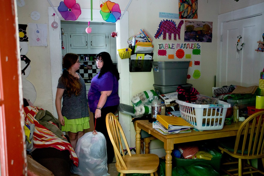Teresa Needham, holding a bag full of clothes, talks with her daughter Vanessa, 13, Friday about the belongings they should bring to their room at the Super 8 motel from their Westbrook apartment. The building's tenants had about an hour to gather belongings before CMP cut electricity to the building.
Gabe Souza/Staff Photographer