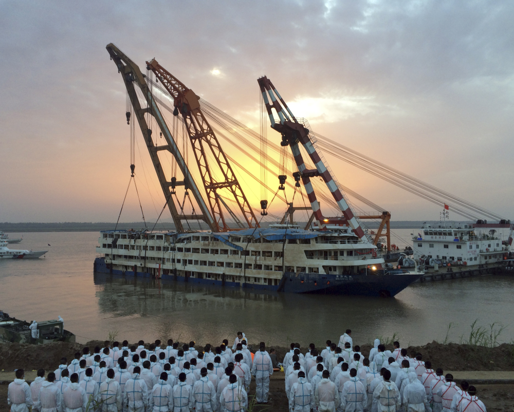 Paramilitary policemen in white overalls wait to recover bodies from the Eastern Star after it is righted and lifted by cranes in the Yangtze River in China on Friday.