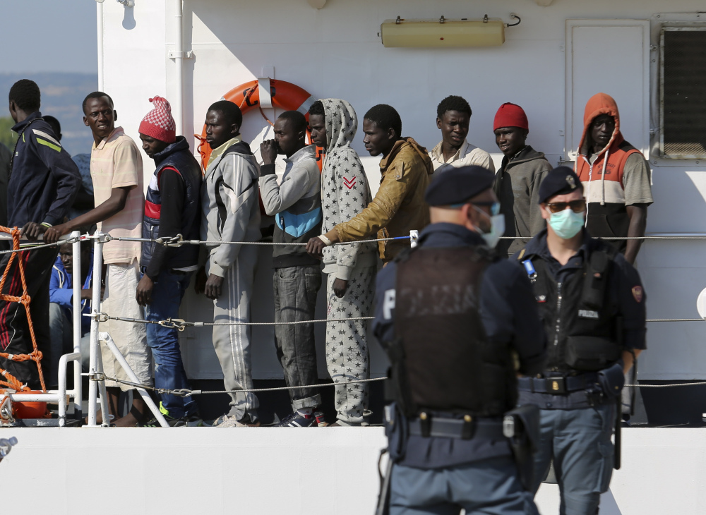 Migrants disembark from the Italian Coast Guard vessel Peluso as they arrive in the Sicilian port town of Augusta on Wednesday.