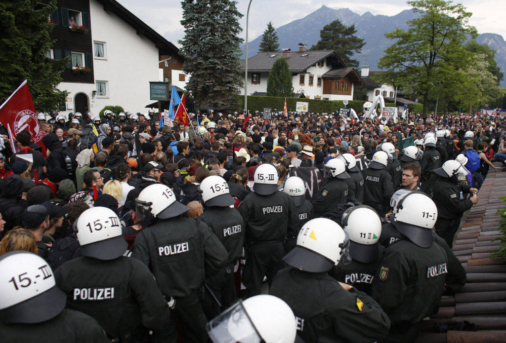 Police stand beside demonstrators during a protest march in Garmisch-Partenkirchen, southern Germany, on Saturday.