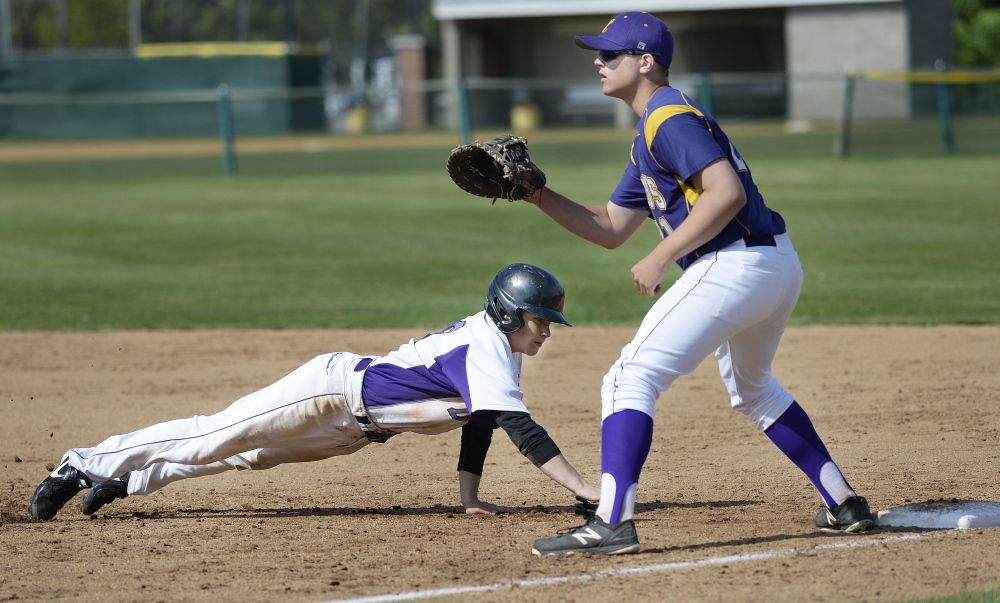 June 9: Kevin Goldberg of Deering dives back to first on a pickoff attempt as Jared Brooks of Cheverus waits for the throw in Tuesday’s Western Class A baseball prelim. Deering won, 12-2.
