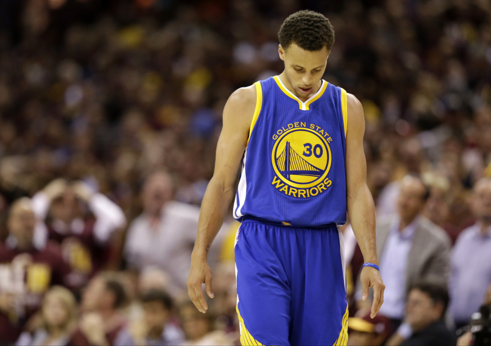 Golden State Warriors guard Stephen Curry walks with his head down during the second half of Game 3 of the NBA Finals on Tuesday night in Cleveland. Curry had a poor first half but got hot later, scoring 17 points in the fourth quarter.