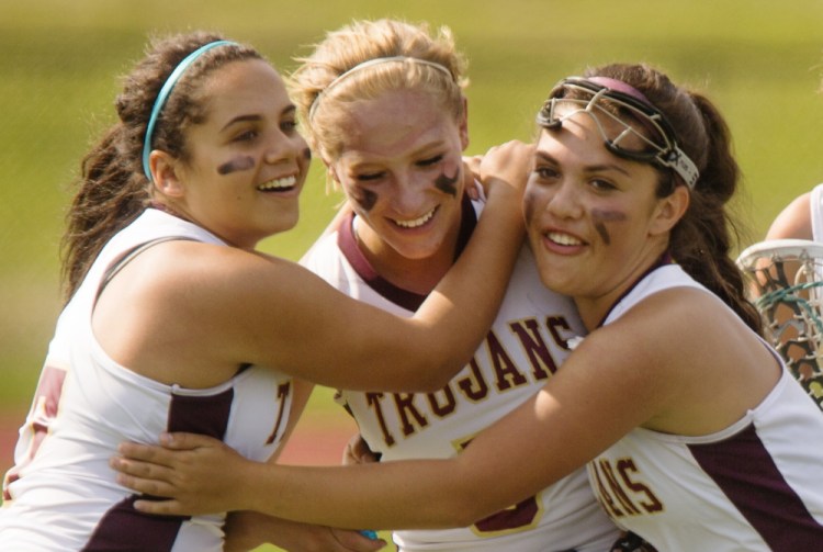 Thornton Academy’s Alana Pettaway, Hannah McAlary and Addy Paradis celebrate after defeating South Portland 9-6 in girls’ Western Class A quarterfinal on Wednesday at Saco. The Trojans trailed 3-1 at halftime, but had a big second half.