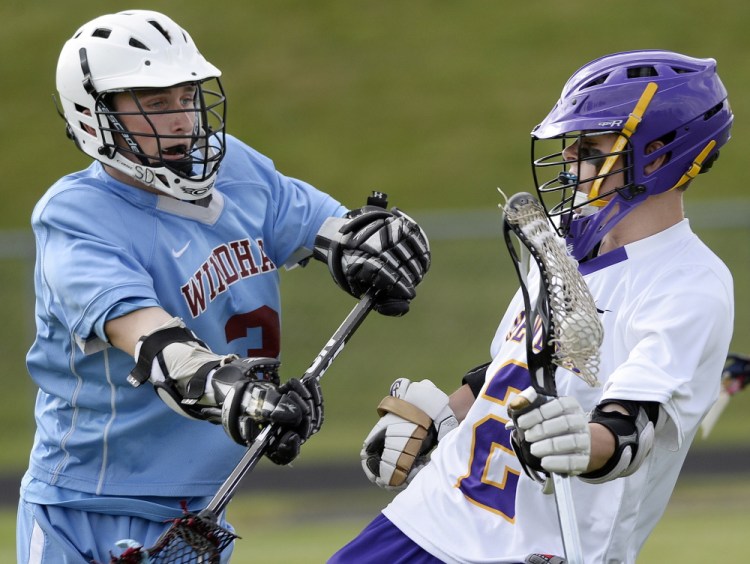 Max Coffin of Cheverus, right, tries to elude Jason Nielsen of Windham during Wednesday’s game.