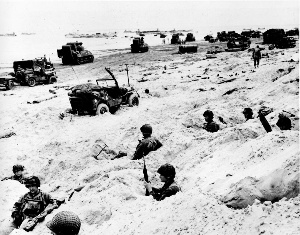 American soldiers of the Allied Expeditionary Force secure a beachhead during initial D-Day landing operations at Normandy, France, on June 6, 1944.