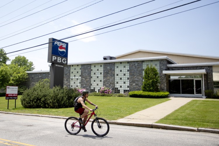 A bicyclist passes the former Pepsi building at 250 Canco Road on Thursday. The building is the proposed new site of Portland’s public works department, but will require voters’ approval.