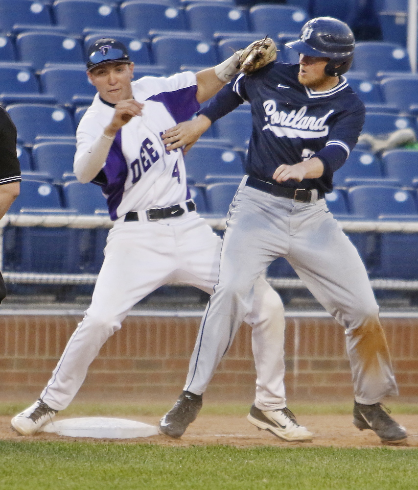 Deering third baseman James Sinclair collides with John Williams of Portland during the fifth inning of top-ranked Portland’s 4-3 victory Thursday night in a Western Class A quarterfinal at Hadlock Field. The ball got away on the play and Fortin was able to score.