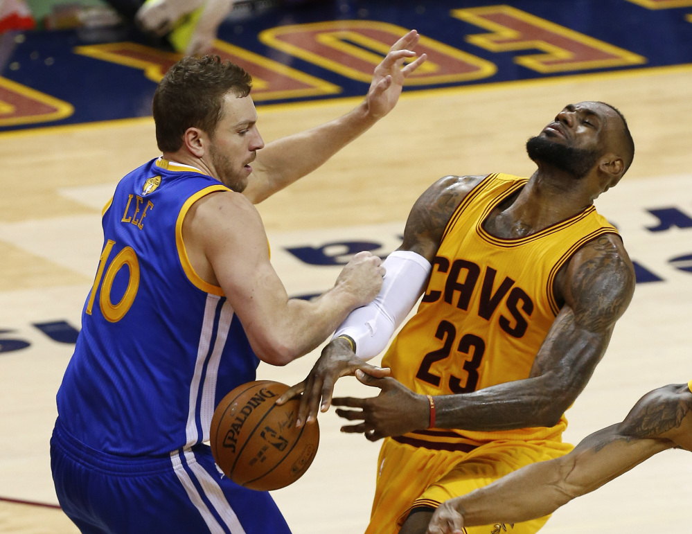 LeBron James loses the ball as he’s hit by Golden State forward David Lee in the second half of Game 4 on Thursday night in Cleveland. James was held to 20 points in the game and suffered a cut on his head in the first half.