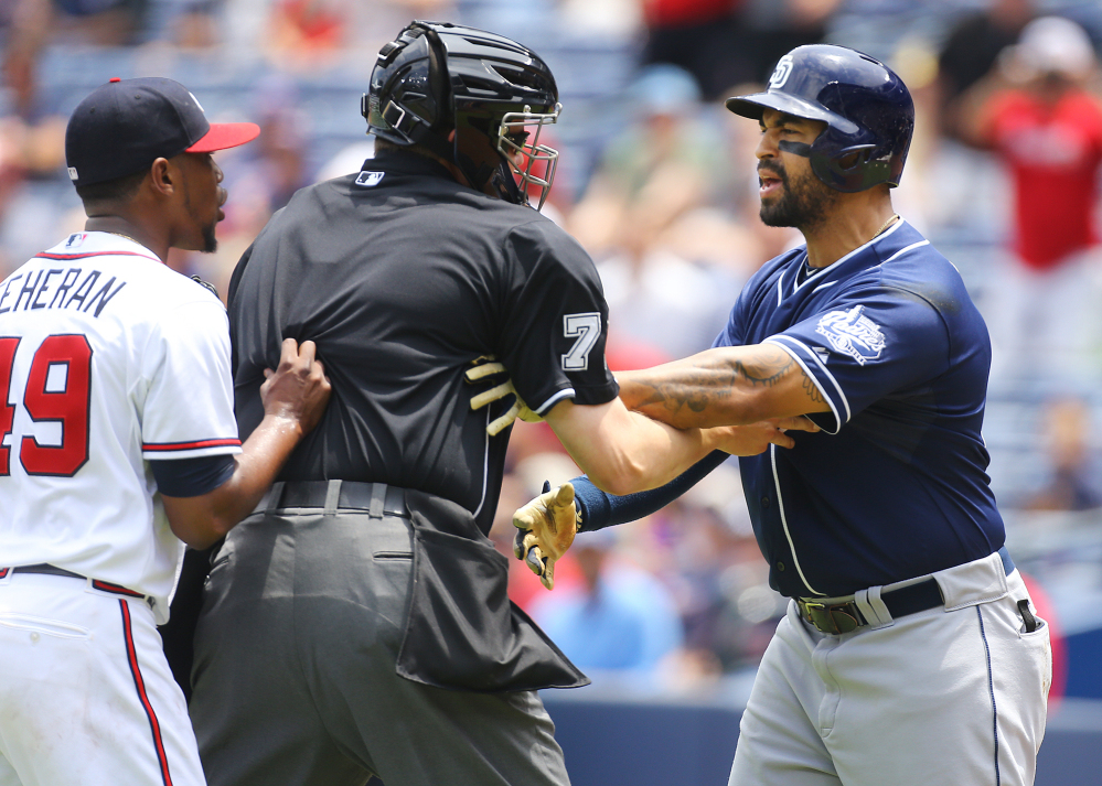 Home plate umpire Jordan Baker separates Atlanta’s Julio Teheran, left, and San Diego’s Matt Kemp after Teheran hit Kemp with a pitch in the first inning of the Padres’ 6-4 win Thursday.