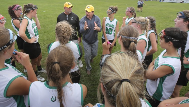 Coach Brooks Bowen, left, and assistant coach Jason Tremblay believed in the winter of 2003-04 that Massabesic High should have a girls’ lacrosse program. Though they knew little about the sport, they grew with the program, and now the Mustangs are the team to beat – again.
