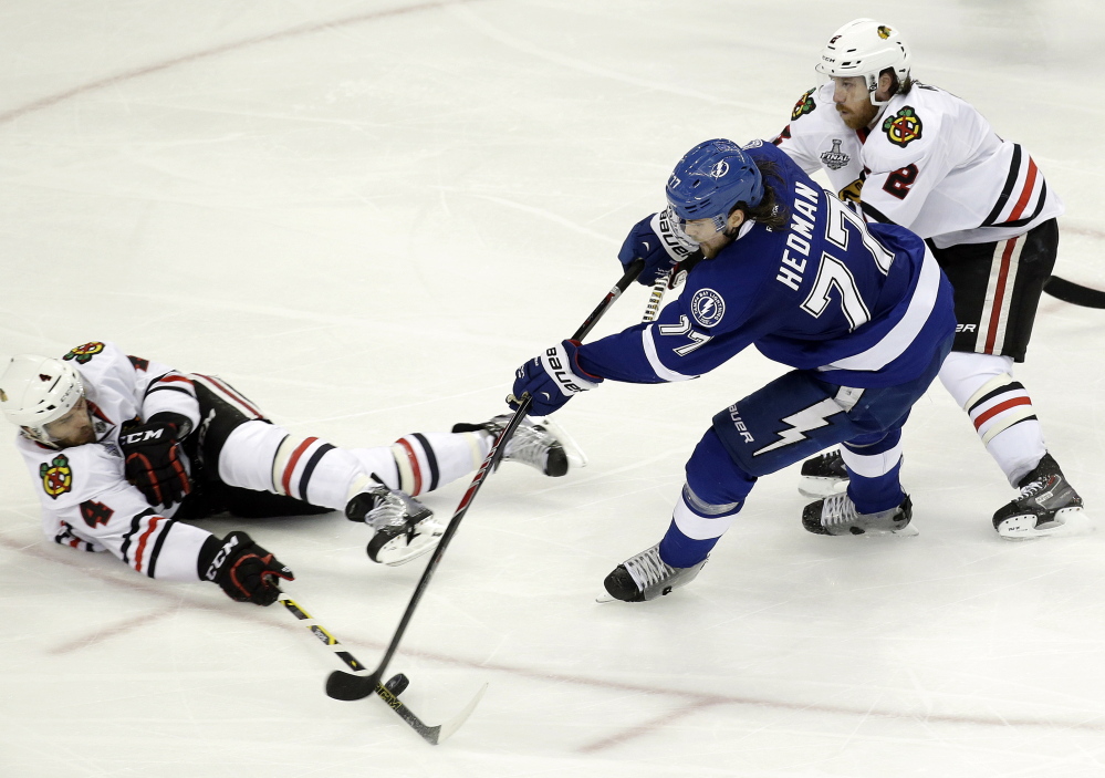 Chicago Blackhawks defensemen Niklas Hjalmarsson, left, and Duncan Keith break up a scoring opportunity by Tampa Bay’s Victor Hedman. Goals by either team have been a rarity in this tightly played championship series.