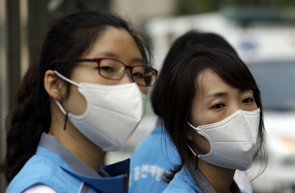 South Korean health workers take precautions against Middle East respiratory syndrome. So far, the virus in South Korea has killed 14 people and spread only in hospitals.