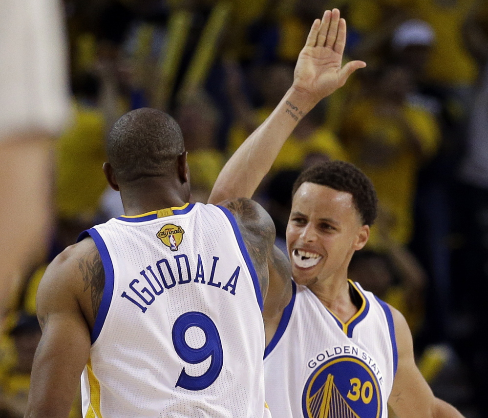 Stephen Curry, right, celebrates with Andre Iguodala during Game 5 of the NBA finals Sunday. The Warriors won 104-91 to take a 3-2 series lead.