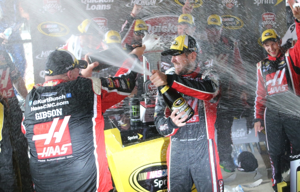 Kurt Busch celebrates with teammates after winning the NASCAR Sprint Cup series auto race at Michigan International Speedway Sunday. The Associated Press