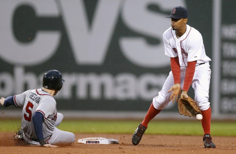 The Atlanta Braves’ Freddie Freeman steals second base on a bad throw from Red Sox catcher Sandy Leon to Xander Bogaerts in the fourth inning Monday night in Boston.