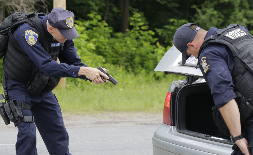 Guns drawn, officers with the New York State Department of Corrections inspect a vehicle Tuesday at a roadblock in Dannemora, N.Y.