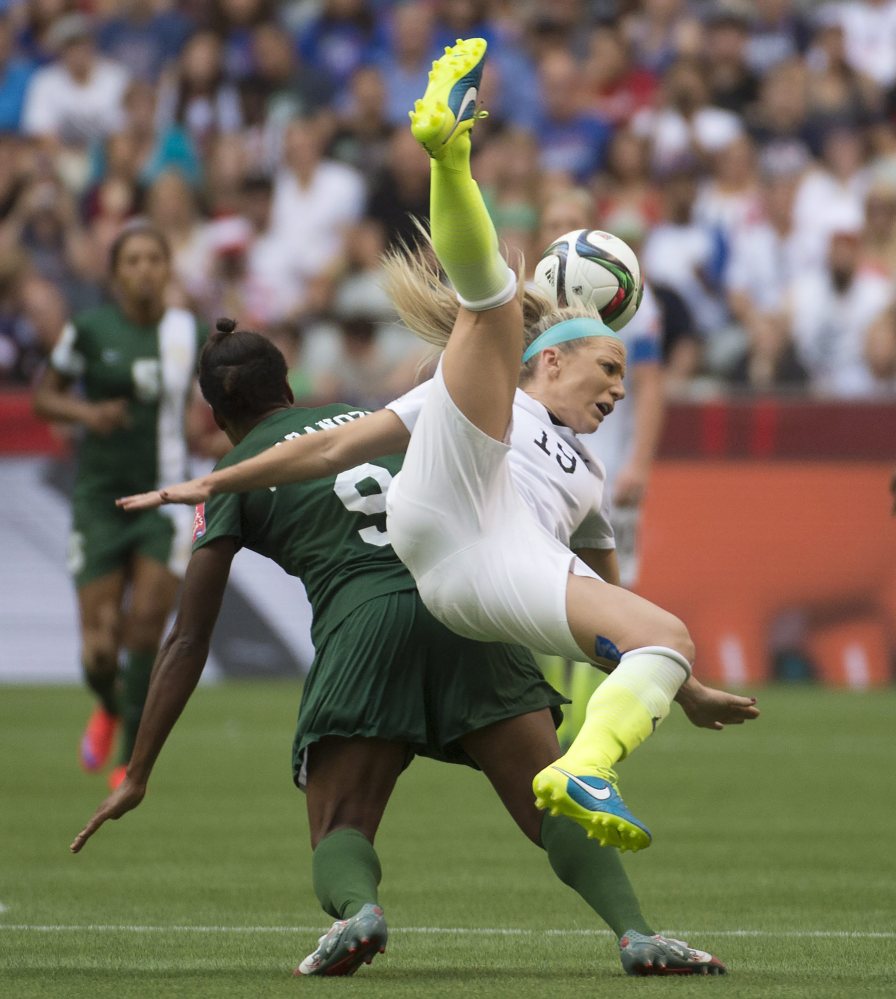 Julie Johnston fights for control of the ball with Nigeria’s Desire Oparanozie during the second half of Tuesday’s match in Vancouver
