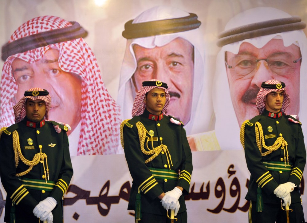 Saudi royal guards stand in front of portraits of King Abdullah bin Abdulaziz, right; Crown Prince Salman bin Abdulaziz, center; and Muqrin bin Abdulaziz in Riyadh, Saudi Arabia. Leaked documents reveal lavish expenditures of royals.